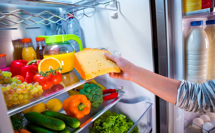 Woman taking cheese from fridge