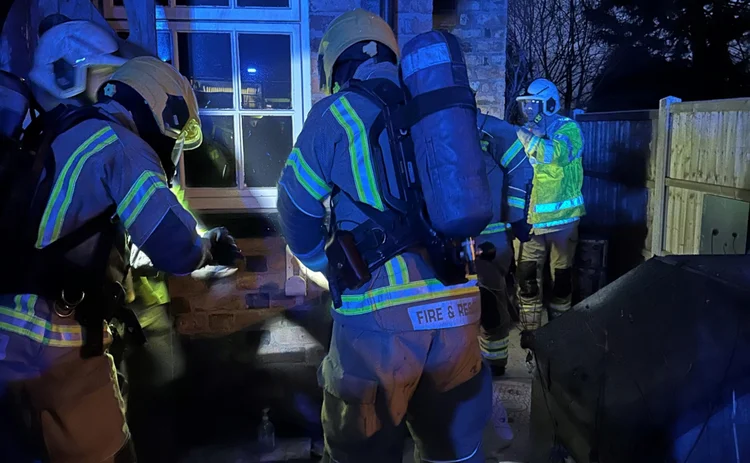 Firefighters outside a house at night