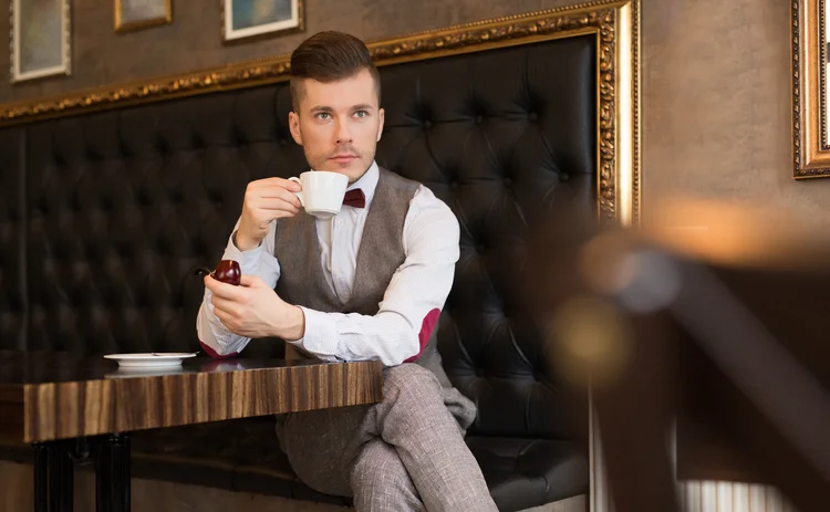  young caucasian man drinking tea at the gentlemen's club.