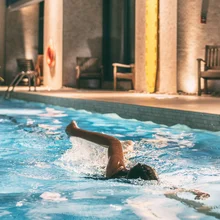 Swimming pool of condo buildings re-opening after COVID-19 confinement. Swimmer woman doing crawl in public pool banner panoramic.