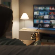 woman relaxing on the couch at home and watching videos on demand on her TV, entertainment