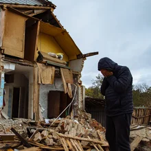 Sad man on ruined house. Hopeless, homelessness, result of military conflicts and natural disasters concept.