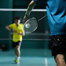 Asian badminton player is hitting in court